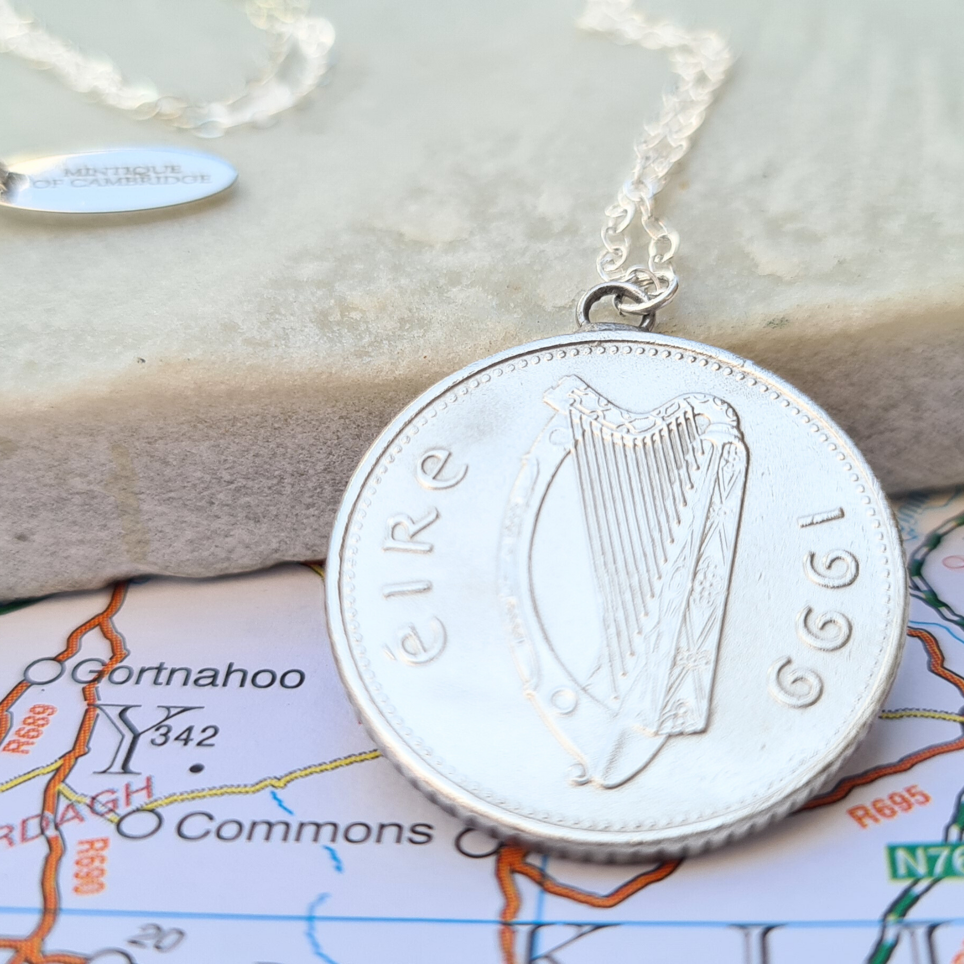 Silver coin necklace with an Irish 10p (Salmon) coin harp design on a map background