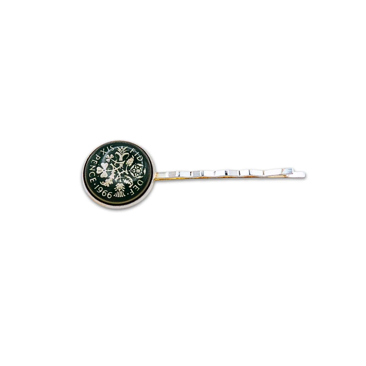 Silver plated hair slide with enamelled green sixpence coin design on a white background