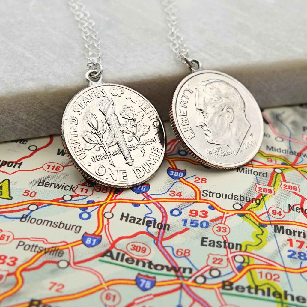 Two silver coin necklaces made from American Dime coins on a map background