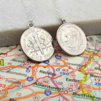 Two silver coin necklaces made from American Dime coins on a map background