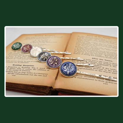 Set of British Queen Elizabeth 2nd sixpence coin enamelled hair slides on an open book