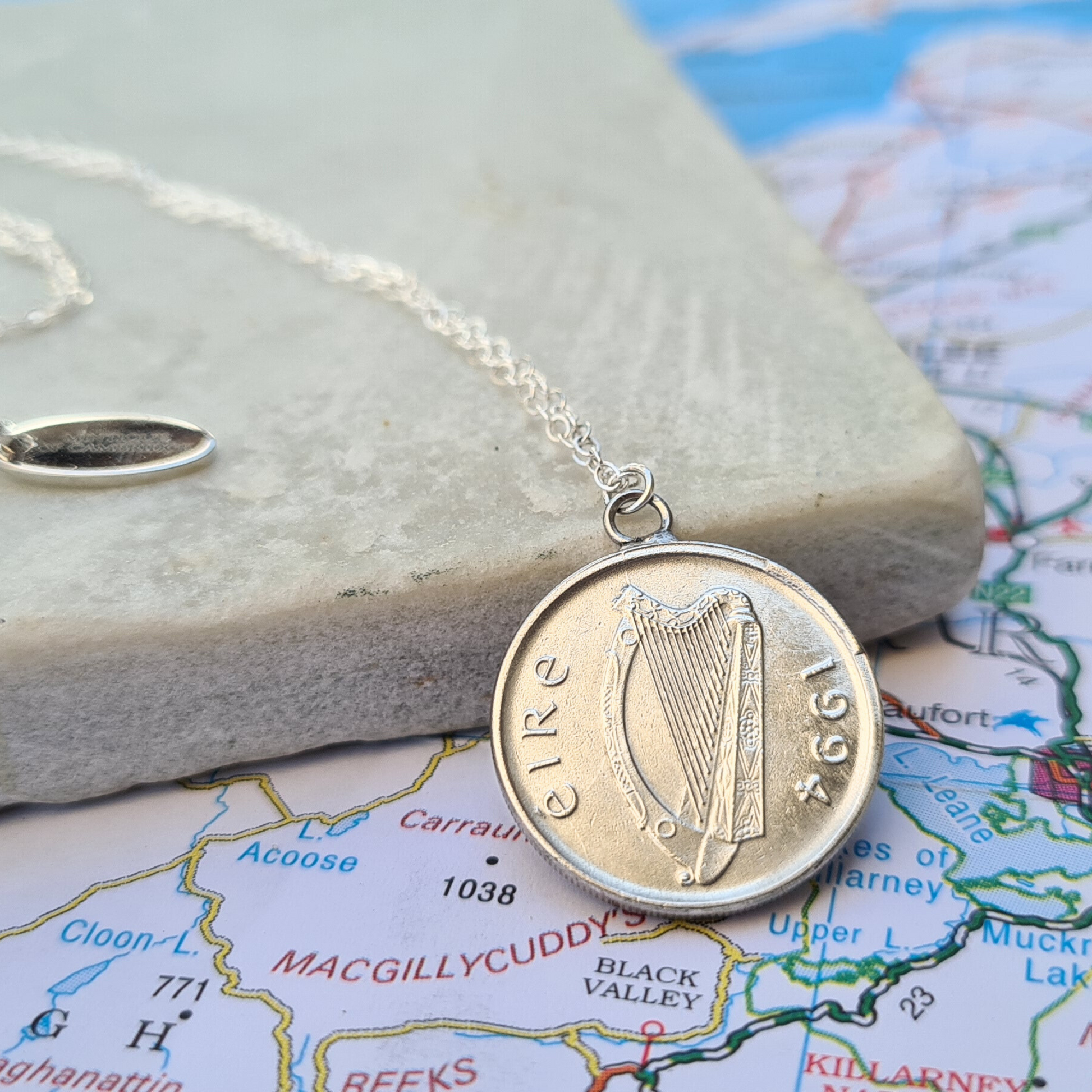 Silver Irish 5p coin necklace with a harp design on a map background