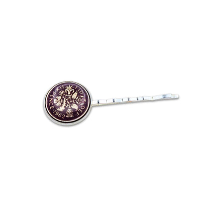 Silver plated hair slide with enamelled purple sixpence coin design on a white background
