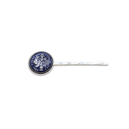 Silver plated hair slide with enamelled blue sixpence coin design on a white background