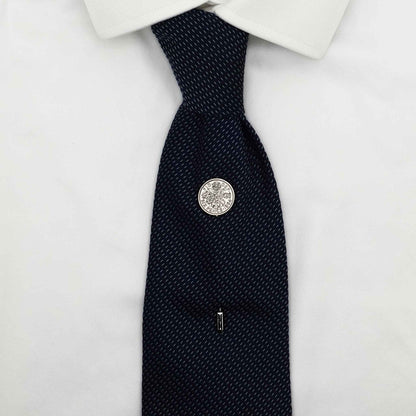 Navy tie on white shirt with Queen Elizabeth 2nd coin tie pin