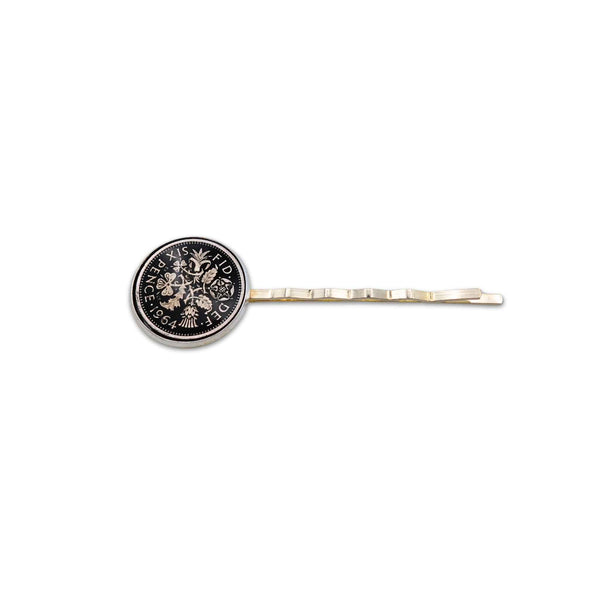 Silver plated hair slide with enamelled black sixpence coin design on a white background