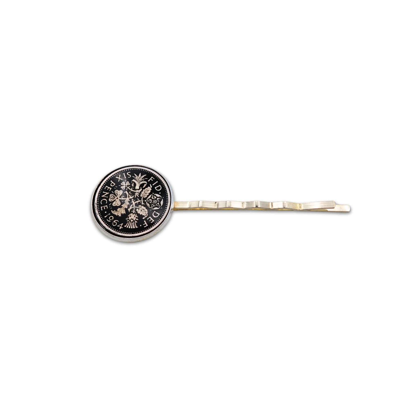 Silver plated hair slide with enamelled black sixpence coin design on a white background