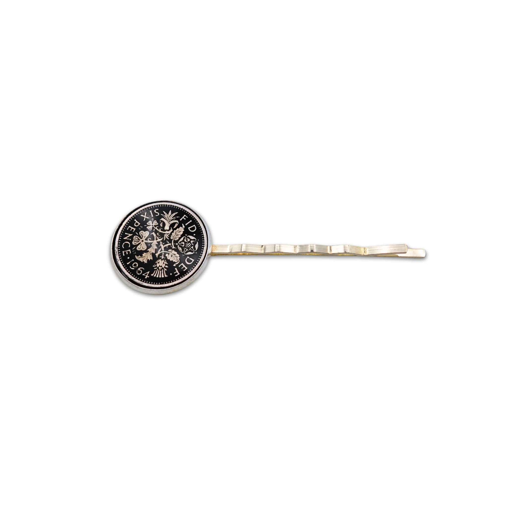 Silver plated hair slide with enamelled black sixpence coin design on a white background