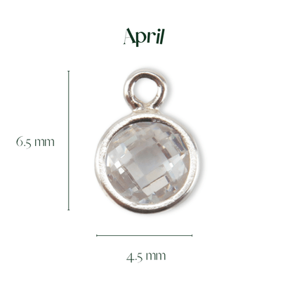 Silver pendant with a clear gemstone, labeled 'April', on a white background.
