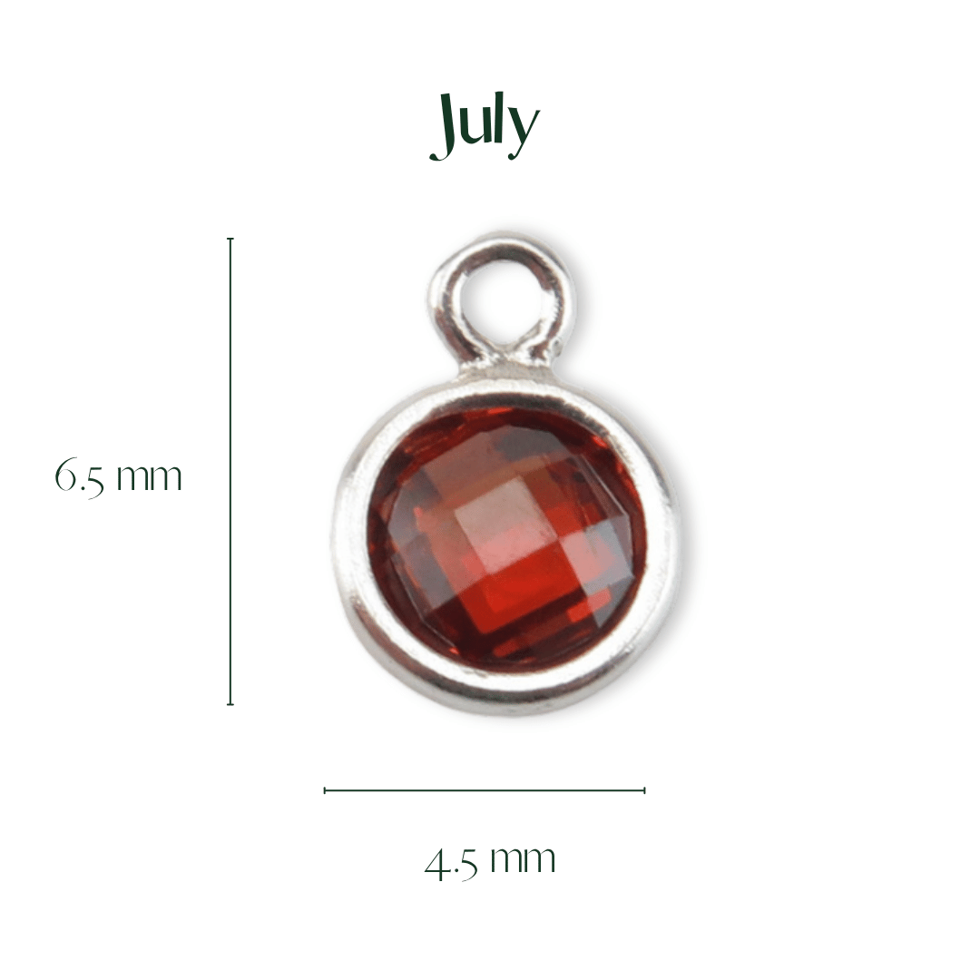 Silver pendant with a red gemstone labeled 'July' on a white background