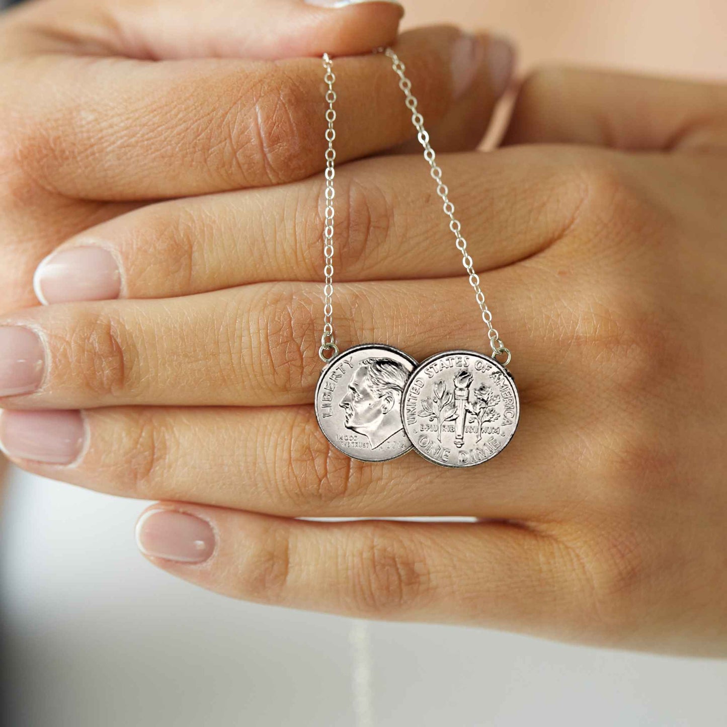 American Dime two coin necklace shiny silver held in hand