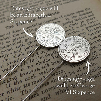 Two silver British sixpence coin tie pins on a piece of paper with text, labeled for different dates (King George VI and Queen Elizabeth II)