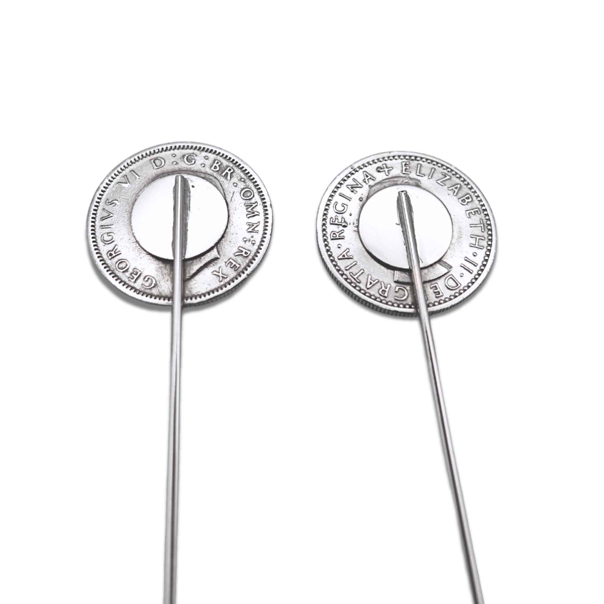 Two silver biritsh sixpence coin tie pins showing the backs on a white background