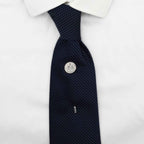 Navy patterned tie with a silver american dime coin tie pin on a white shirt