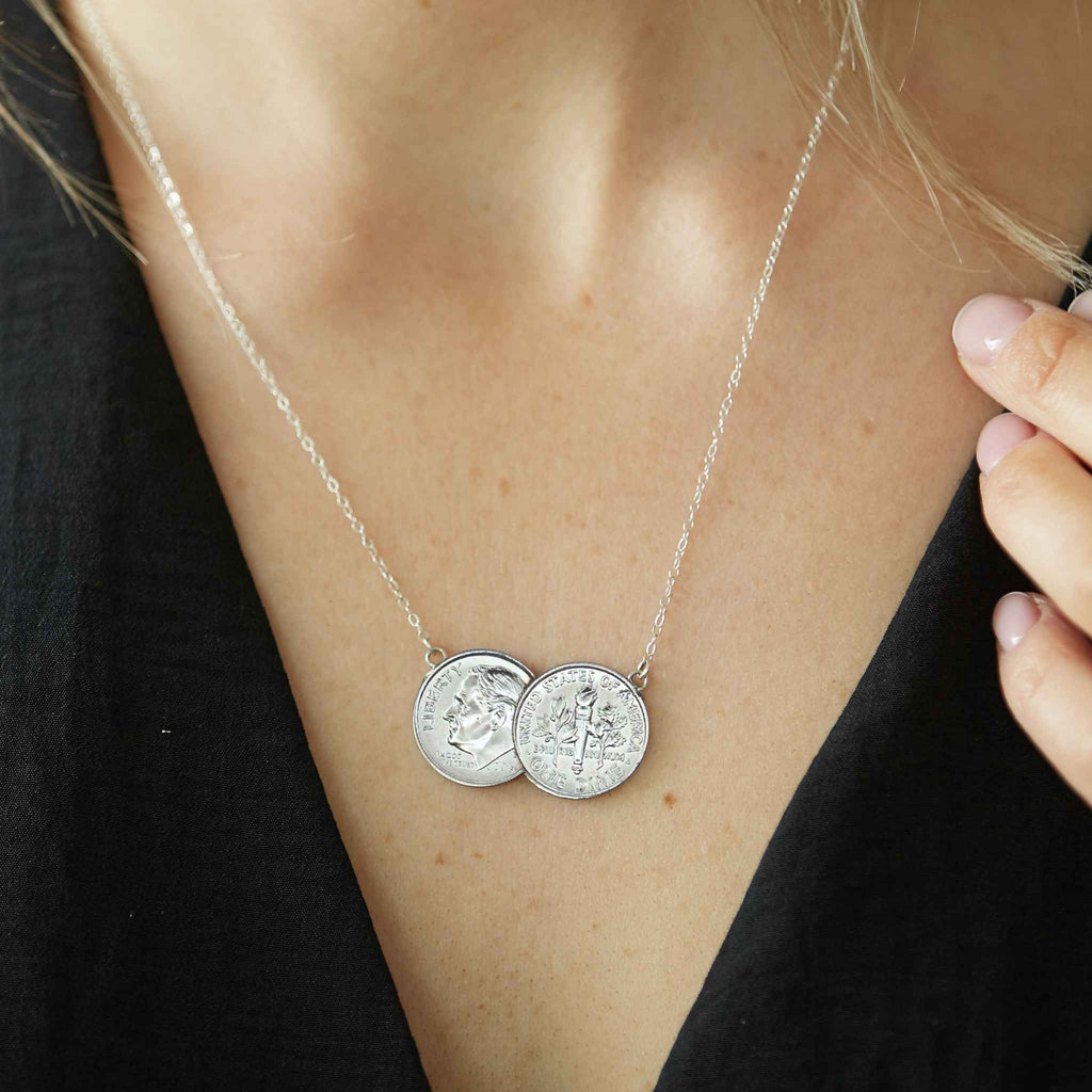 American Dime double coin necklace with silver chain worn by woman with a black top.