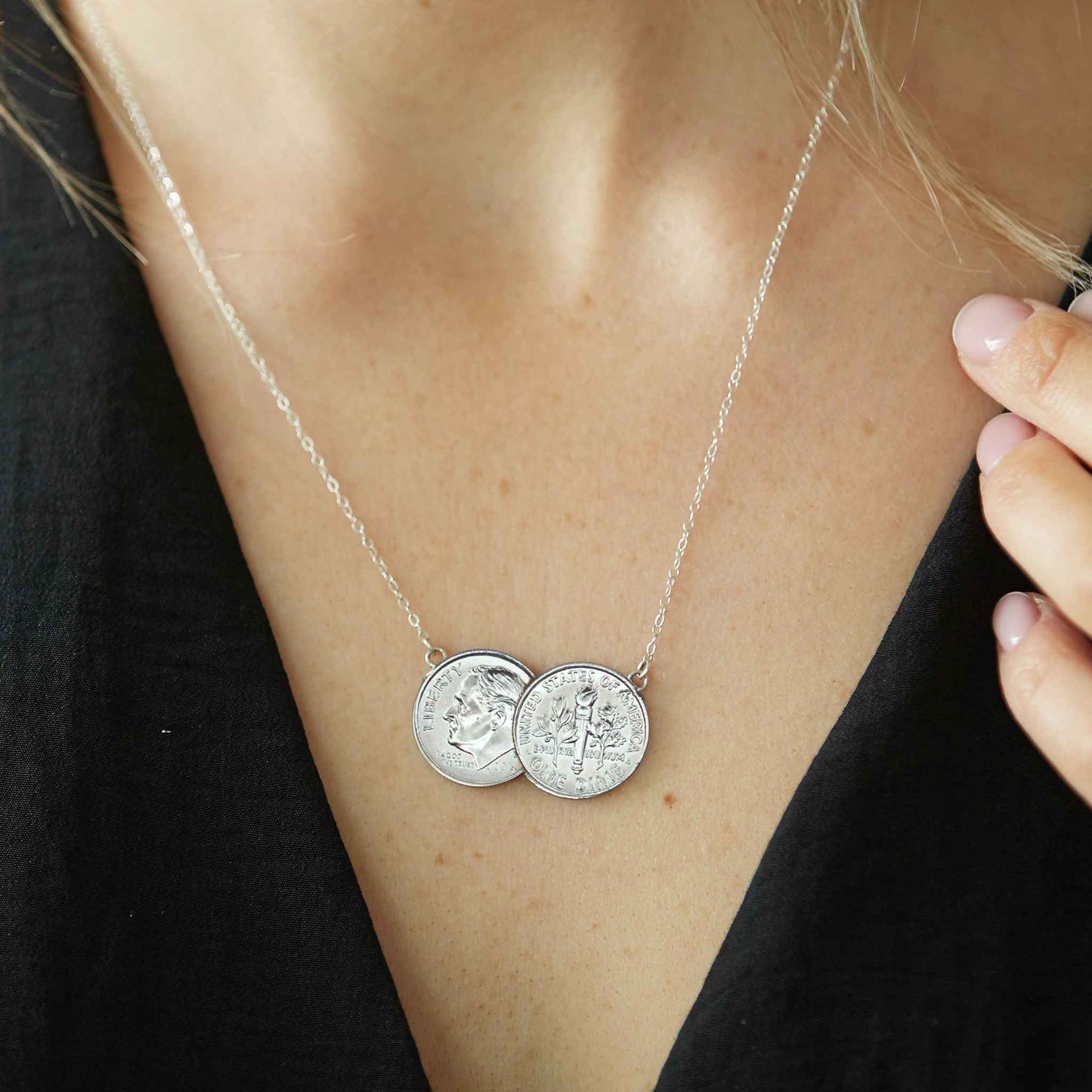 American Dime double coin necklace with silver chain worn by woman with a black top.