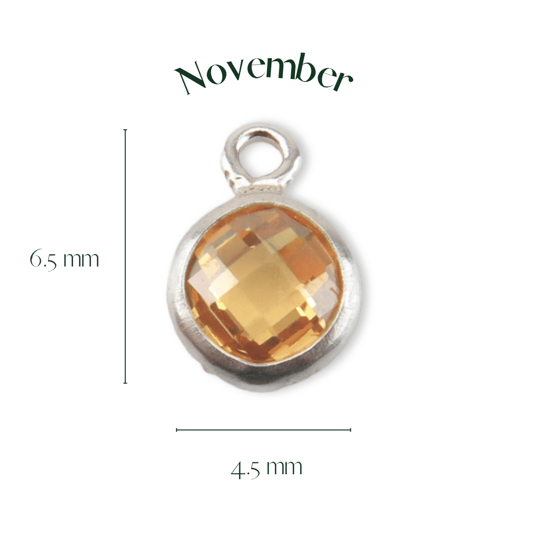 Silver pendant with a yellow gemstone labeled 'November' on a white background