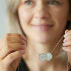 sixpence double coin necklace with sterling silver chain held in hands
