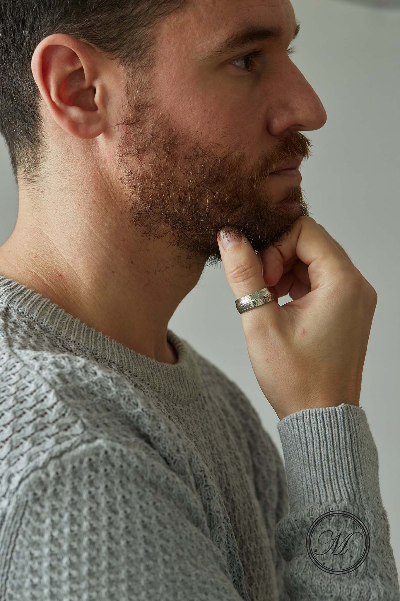 Half crown coin ring worn on thumb, hand under chin