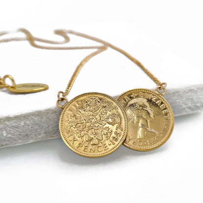 Gold necklace with two coins on a white background